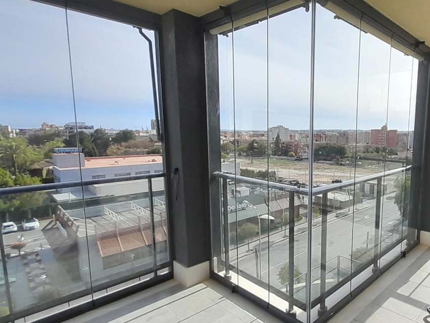 Instalación de cortinas de cristal en balcón con forma irregula